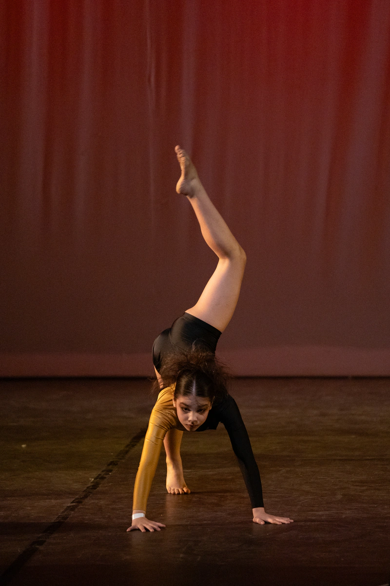 Bailarina realizando una figura acrobática en el escenario