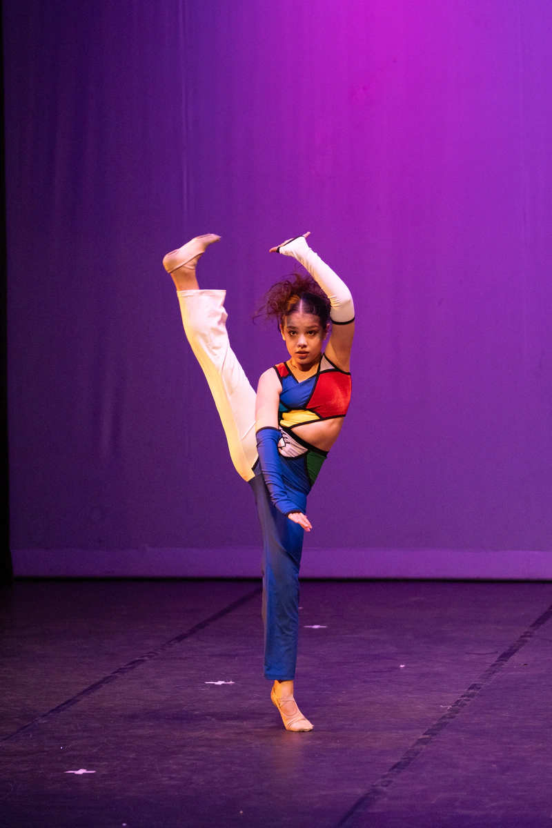 Bailarina en una pose de danza con fondo violeta