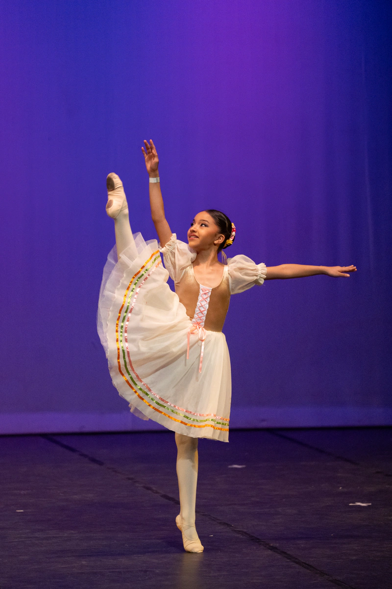 Bailarina de ballet en equilibrio con vestido blanco