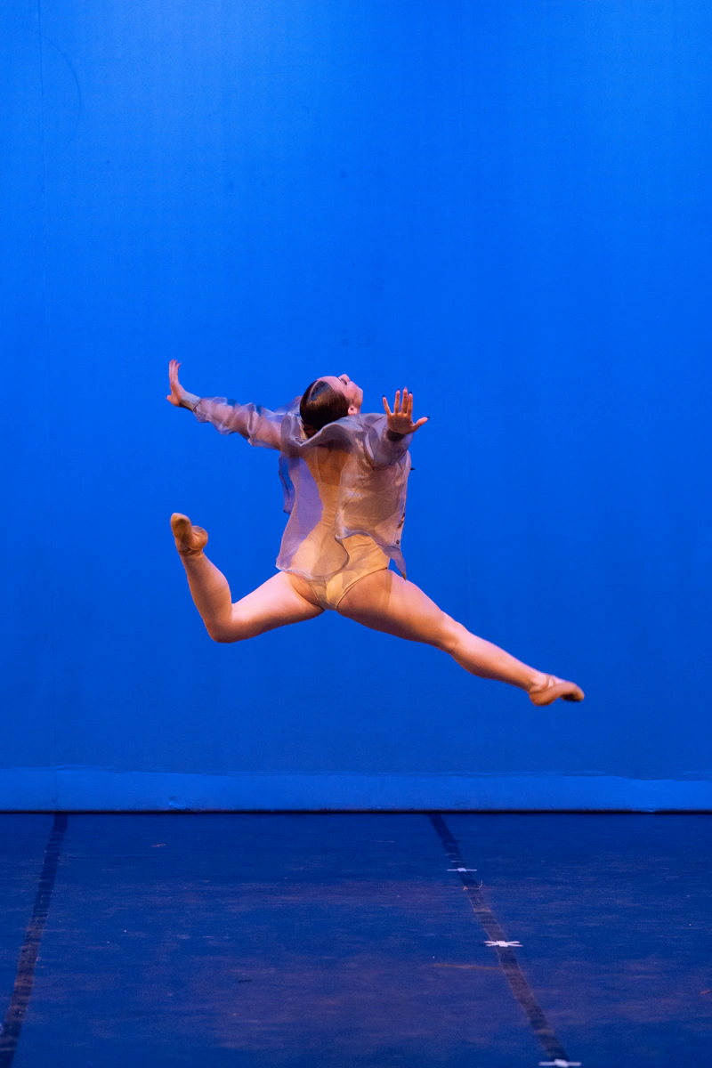 Bailarina en salto frente a un fondo azul